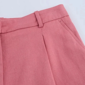 Close-up of pink linen-blend shorts showing side pockets and belt loops with fine stitching