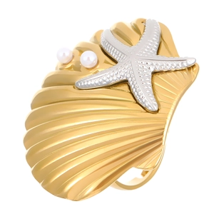 Detailed view of a gold shell ring featuring silver starfish and white pearl accents