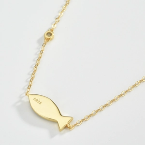 Macro shot of S925 hallmark on golden fish pendant necklace with polished finish