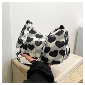 Gros plan détaillé d'un petit sac à main avec motif de cœur noir et blanc et poignée