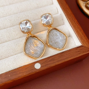 Gros plan de boucles d'oreilles vintage avec pierres et incrustations dorées sur boîte