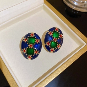 Vintage style gold earrings with dark blue oval base and green emerald-cut gem stones