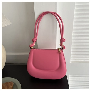 Detail of soft bright pink saddle bag with puffy cloud texture and knot handle