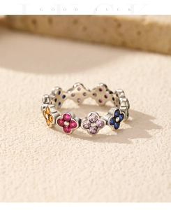 Macro detail of 925 silver clover ring featuring colorful gemstones and good luck text