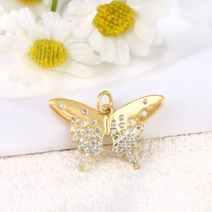 Macro detail of gold-plated butterfly charm pendant with sparkling crystals for DIY jewelry