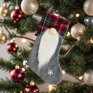 Detail of Christmas gnome stocking with plaid cuff and snowflake embroidery on a tree