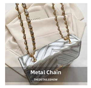 Close-up of silver quilted crossbody bag featuring metal chain strap and luxury texture
