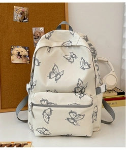 Detail of cream backpack featuring grey butterfly prints and functional side buckles
