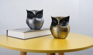 Detail of gold and silver owl resin statues with dotted texture for home decor