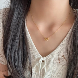 Elegant 925 sterling silver bow necklace in gold finish worn by a female model