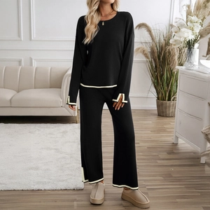 Women's black knit two-piece set featuring contrast beige trim and wide-leg trousers