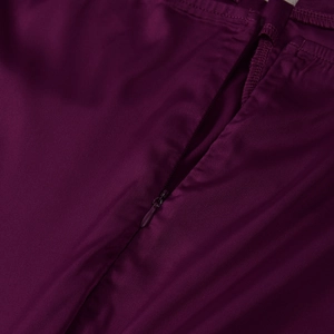 Detailed close-up of invisible zipper and stitching on maroon satin sling maxi dress
