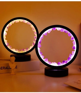Detail of warm glow illuminating natural purple amethyst cluster in black circular lamp