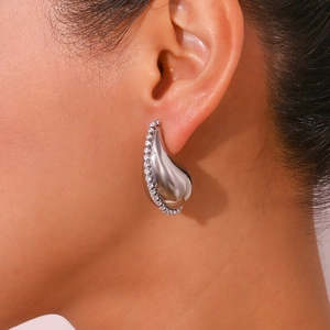 Vue macro d'une boucle d'oreille goutte d'argent avec zircons blancs sur le bord