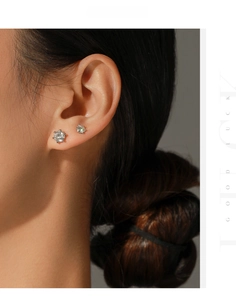Close-up of classic 6-prong round moissanite earrings in 5mm and 6.5mm sizes on a model