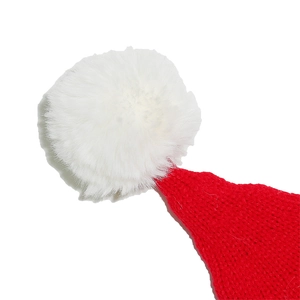Close-up of fluffy white faux fur pom-pom and red knit texture of the Christmas hat