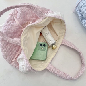 Dettaglio della borsa trapuntata a quadretti rosa con pizzo e vista dell'interno
