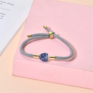 Detailed shot of handmade adjustable grey cord bracelet with blue heart stone bead