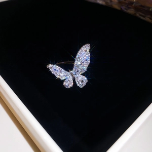 Macro shot of silver butterfly ring with pavé-set crystals in a black velvet box
