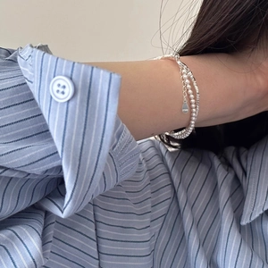 Elegant double-layer S925 silver beaded bracelet with pearls worn on a female wrist