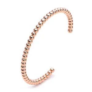 Macro shot of rose gold bead bracelet with polished surface and open cuff design