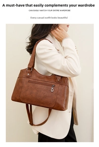 Détail du sac à main marron en cuir texturé avec fermetures éclair en métal