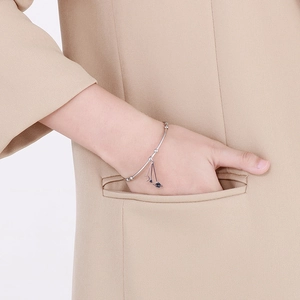 Detail view of silver celestial charm bracelet featuring moon and star pendants on wrist