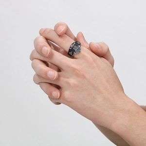 Close-up of retro Nordic Viking compass ring with runes on a male finger in silver-black