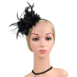 Close-up of black bridal feather fascinator with mesh veil and beads on a model