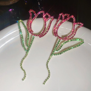 Macro detail of tulip-shaped earrings with sparkling pink and green rhinestones