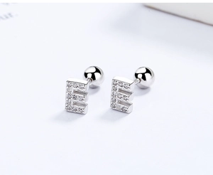 Detail of silver letter E stud earring with zircon stones and screw ball back design
