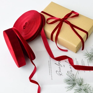 Red velvet ribbon rolls for Christmas gift wrapping and DIY bows on a gift box