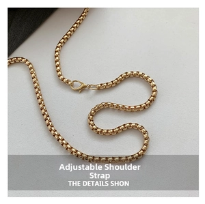 Detailed macro view of the adjustable gold chain strap with metallic lobster clasp closure