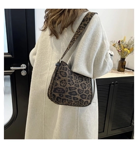 Detail of the leopard print crossbody bag with a wide matching shoulder strap on a model