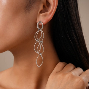 Detail view of silver geometric multilayer earrings on model with high metallic luster