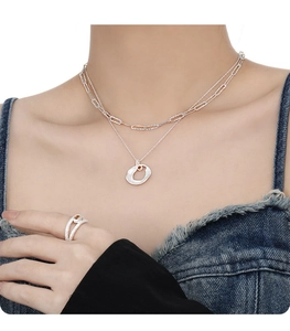 Detail of silver double-layered necklace with amber stone and organic ring set