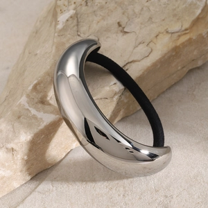 Polished silver metal hair ring with black elastic band on natural stone base