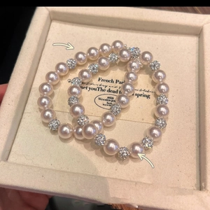 French retro double pearl bracelets with rhinestone spacers on a jewelry display tray