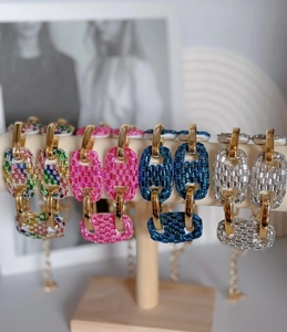Detailed view of colorful oversized rhinestone pig nose necklaces on a display stand