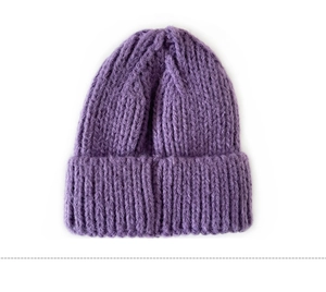 Close-up of purple chunky knit beanie showing soft wool texture and embroidery detail