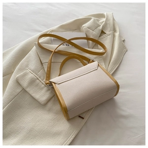 Detail of white and yellow textured leather handbag with silver metal buckle