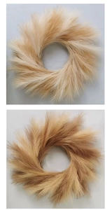 Detail view of two artificial pampas grass wreaths with fluffy light brown texture