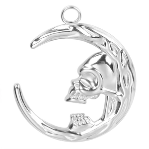Macro detail of polished stainless steel crescent moon and skull pendant accessory