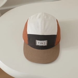 Dettaglio del cappello per bambini a cinque pannelli multicolore con etichetta TIDE