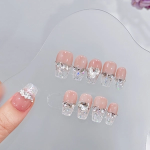 Handmade nude pink press-on nails with silver glitter gradient and heart rhinestone
