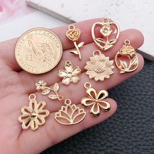 Golden flower pendants compared with a dollar coin to show the actual product size