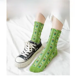 Close-up of green cotton crew socks with knit texture and yellow floral embroidery