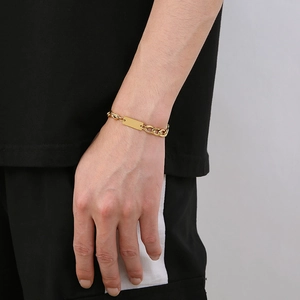 Gros plan d'un bracelet NK gourmette en acier inoxydable doré avec plaque carrée à graver