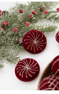 Détail de boules de Noël floquées rouges avec motifs en spirale à paillettes dorées
