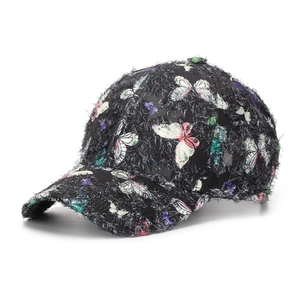 Detailaufnahme der schwarzen Baseballkappe mit bunten Schmetterlingen und flauschiger Textur